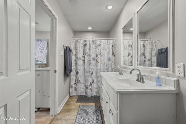 bathroom featuring tile patterned flooring, double vanity, recessed lighting, and a sink