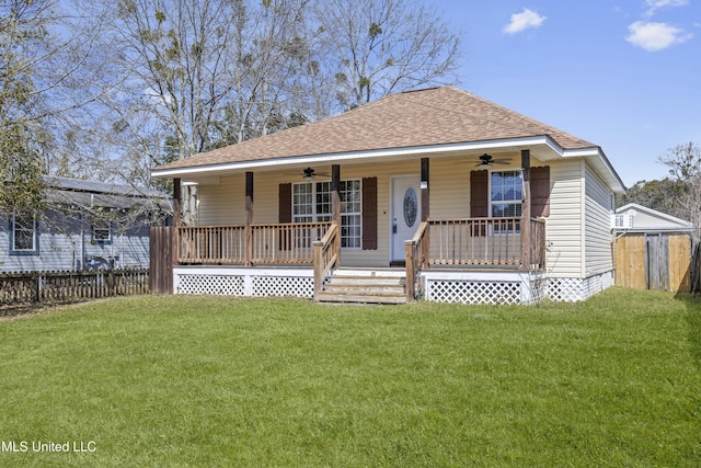 bungalow-style house featuring covered porch, a front lawn, a ceiling fan, and roof with shingles