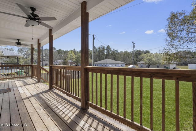 wooden terrace featuring a yard and a ceiling fan