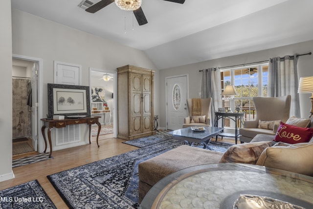 living room featuring vaulted ceiling, wood finished floors, visible vents, and ceiling fan