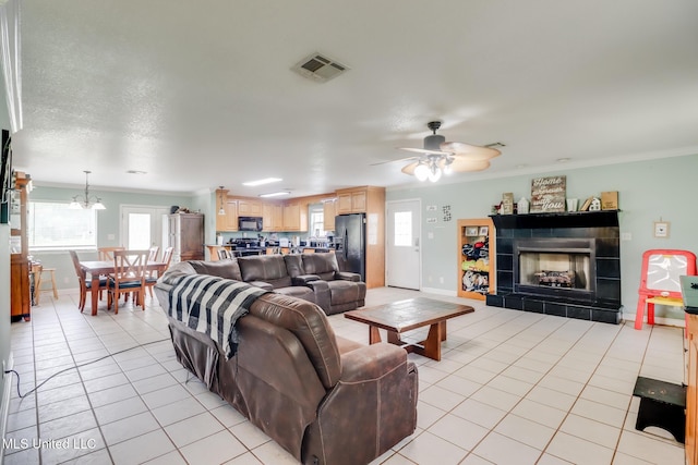 5421 Espy Ave, Long Beach, MS 39560 - living room featuring ornamental molding, a fireplace, light tile patterned floors, ceiling fan, and a chandelier