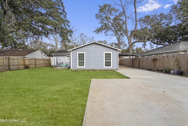 rear view of house featuring a fenced backyard and a yard