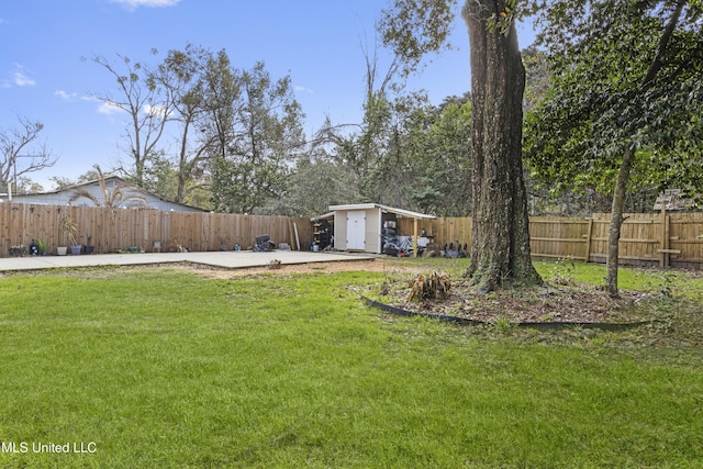 view of yard featuring a fenced backyard, an outdoor structure, and a patio