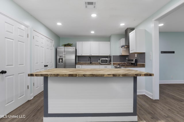 kitchen featuring stainless steel appliances, visible vents, white cabinetry, wooden counters, and tasteful backsplash