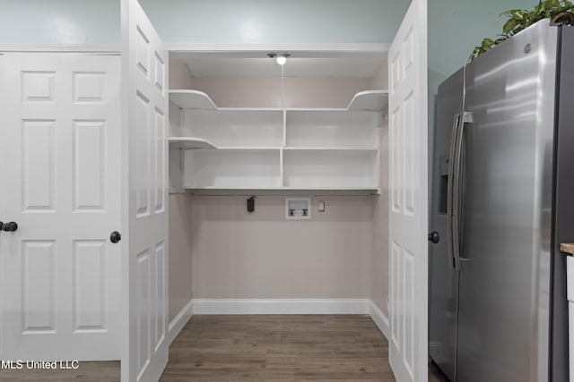 interior space with laundry area, washer hookup, wood finished floors, and baseboards