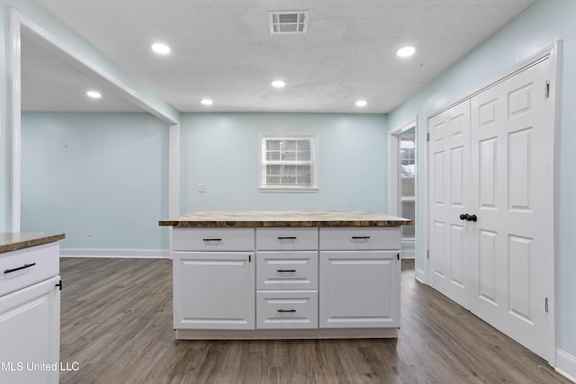 kitchen featuring white cabinetry, visible vents, and wood finished floors