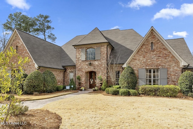 view of front of property featuring roof with shingles and brick siding