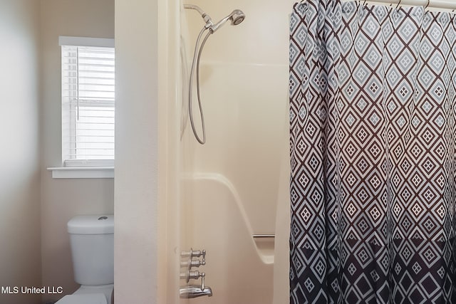 bathroom with curtained shower and toilet