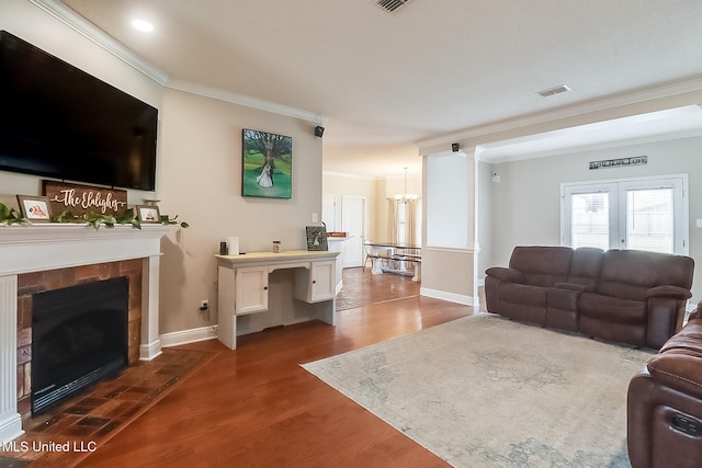 living room with dark wood-type flooring, ornamental molding, a tile fireplace, and french doors