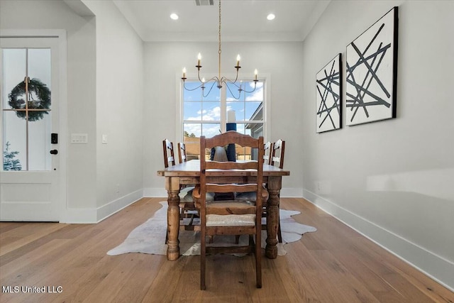 dining space with wood-type flooring and a notable chandelier