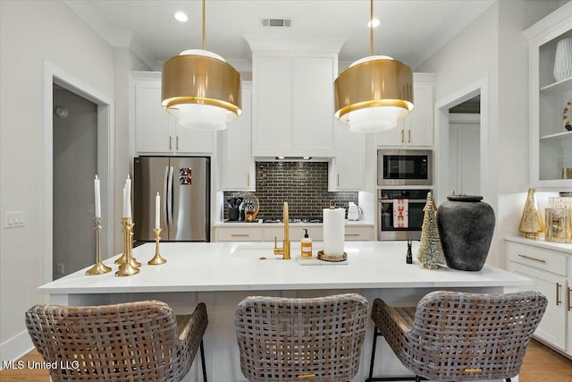 kitchen featuring pendant lighting, white cabinets, and stainless steel appliances