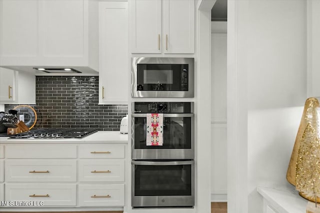 kitchen featuring white cabinets, stainless steel appliances, and tasteful backsplash