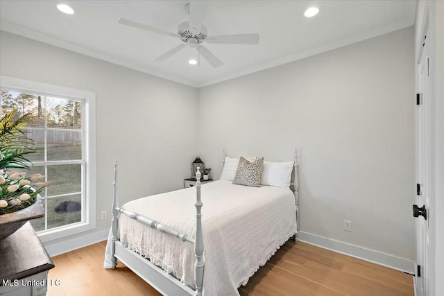 bedroom featuring hardwood / wood-style floors, ceiling fan, and ornamental molding