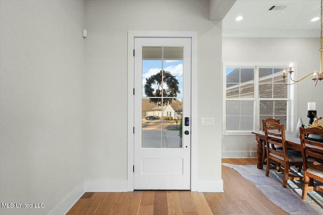 foyer entrance featuring hardwood / wood-style floors and an inviting chandelier