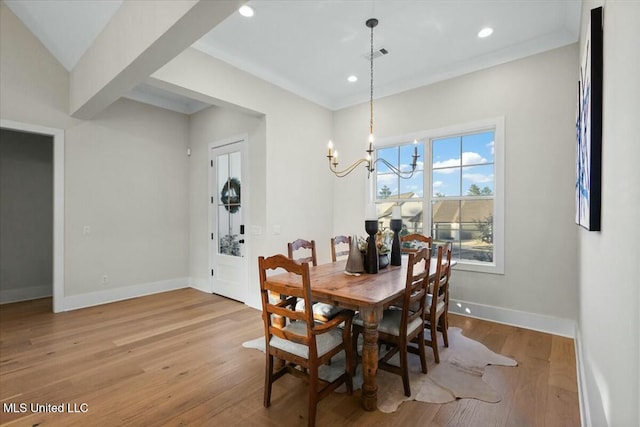 dining room featuring crown molding, a notable chandelier, and light wood-type flooring