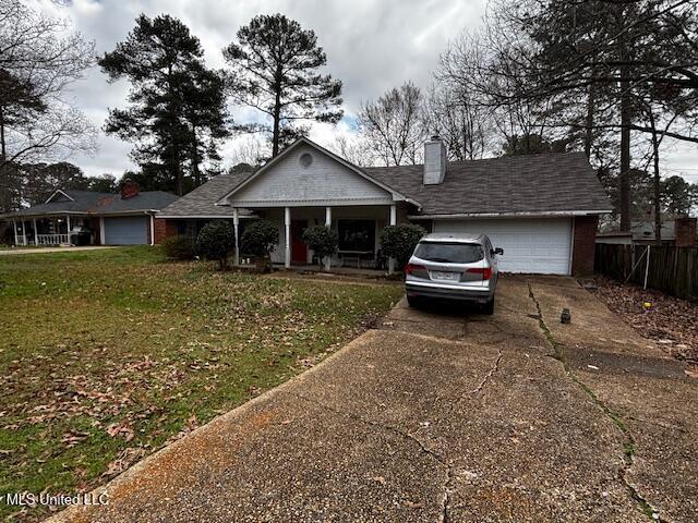 ranch-style home featuring a garage and a front lawn