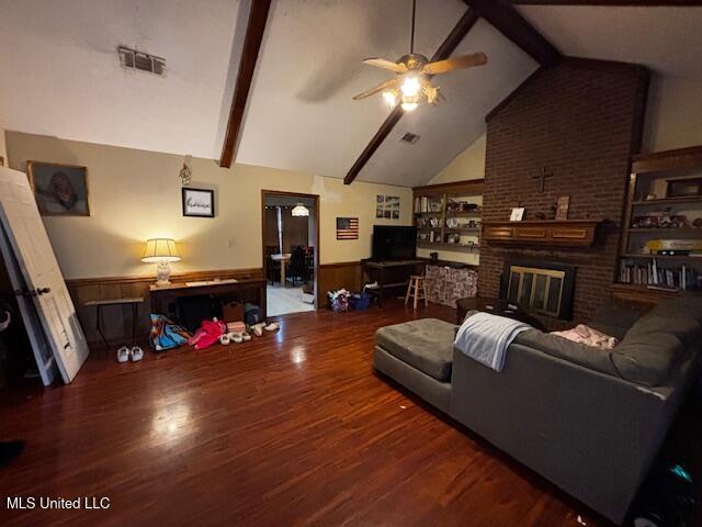 living room featuring high vaulted ceiling, a fireplace, beamed ceiling, dark hardwood / wood-style flooring, and ceiling fan