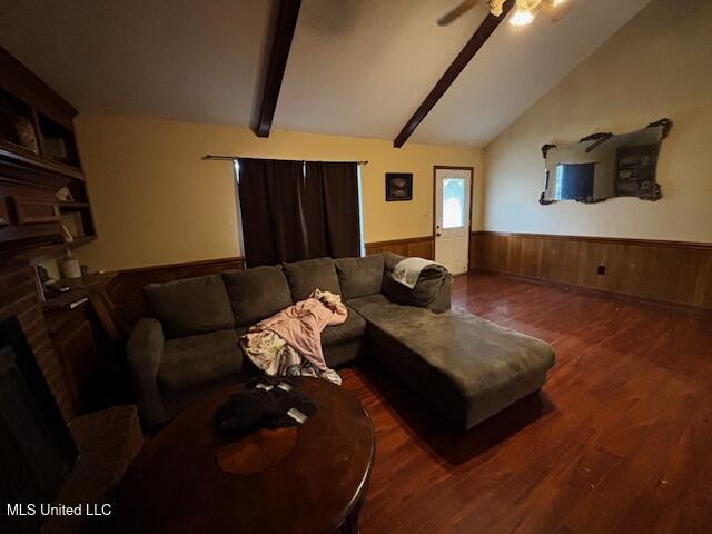 living room featuring lofted ceiling with beams, ceiling fan, a brick fireplace, and dark hardwood / wood-style flooring