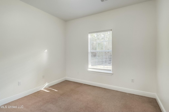 unfurnished room featuring light carpet