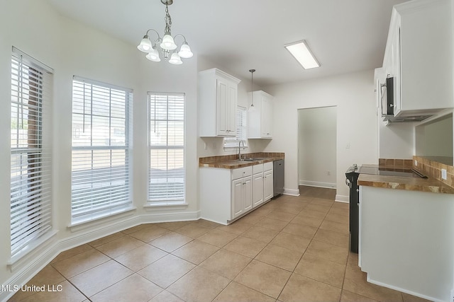 kitchen featuring hanging light fixtures, light tile patterned floors, and white cabinets