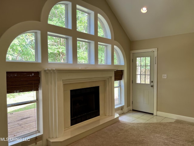 8004 Martin Bluff Rd, Gautier, MS 39553 - unfurnished living room with light tile patterned floors, a fireplace with raised hearth, light colored carpet, recessed lighting, and healthy amount of natural light
