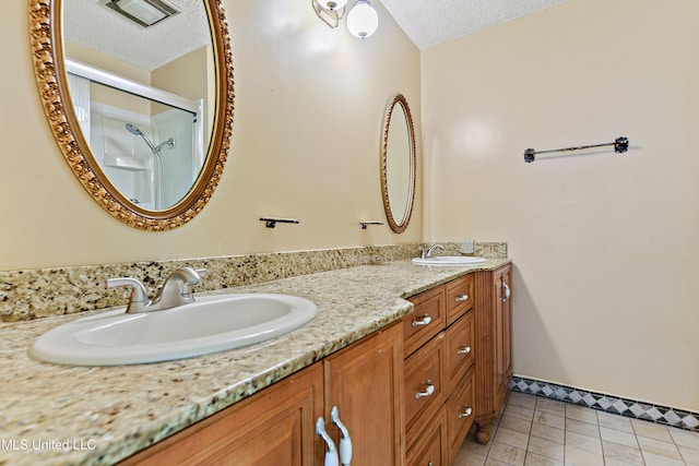 full bathroom featuring a textured ceiling, an enclosed shower, and a sink