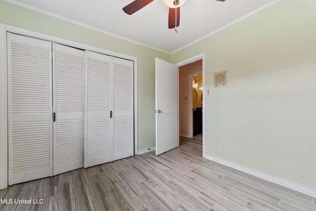 unfurnished bedroom with crown molding, ceiling fan, baseboards, light wood-type flooring, and a closet