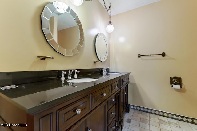 bathroom featuring a sink, baseboards, and double vanity