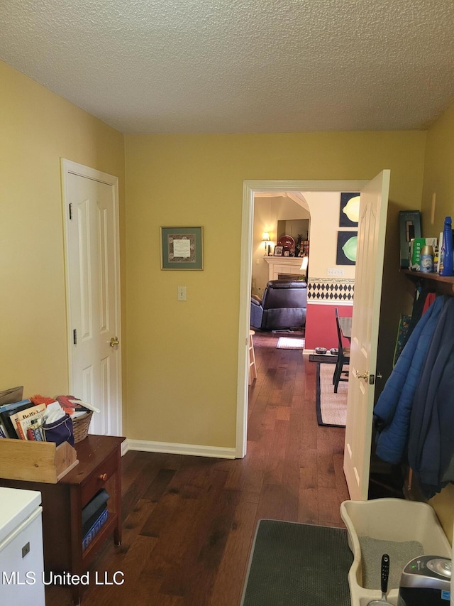 8475 Windersgate Dr, Olive Branch, MS 38654 - corridor featuring wood-type flooring, a textured ceiling, baseboards, and arched walkways