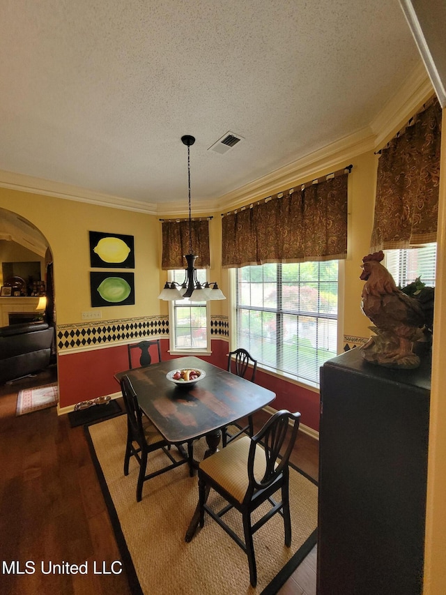 8475 Windersgate Dr, Olive Branch, MS 38654 - dining room with arched walkways, ornamental molding, a textured ceiling, and wood finished floors