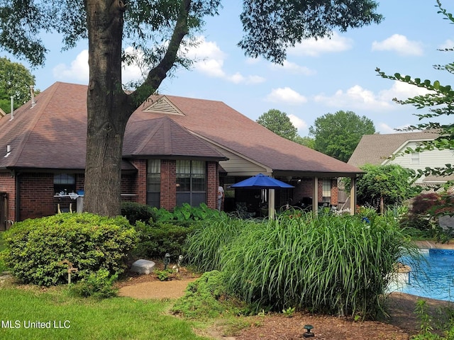 8475 Windersgate Dr, Olive Branch, MS 38654 - rear view of house with brick siding, an outdoor pool, and a shingled roof