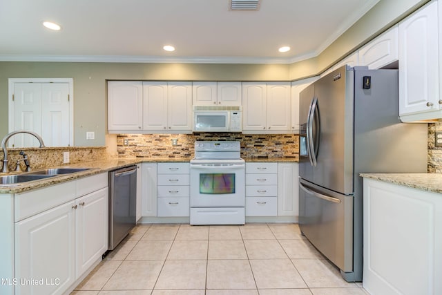 kitchen featuring light stone countertops, appliances with stainless steel finishes, sink, white cabinets, and crown molding