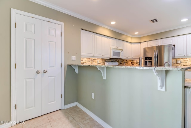 kitchen with white cabinets, light stone counters, light tile patterned floors, and stainless steel fridge with ice dispenser