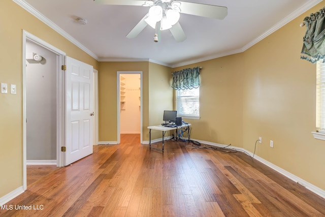 unfurnished office with crown molding, wood-type flooring, and ceiling fan