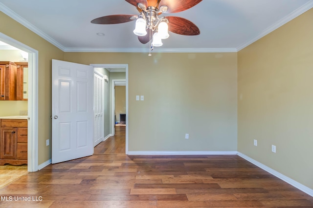 unfurnished bedroom with ceiling fan, hardwood / wood-style flooring, and ornamental molding