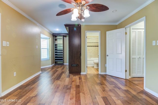 unfurnished bedroom with ceiling fan, connected bathroom, ornamental molding, dark hardwood / wood-style floors, and a closet