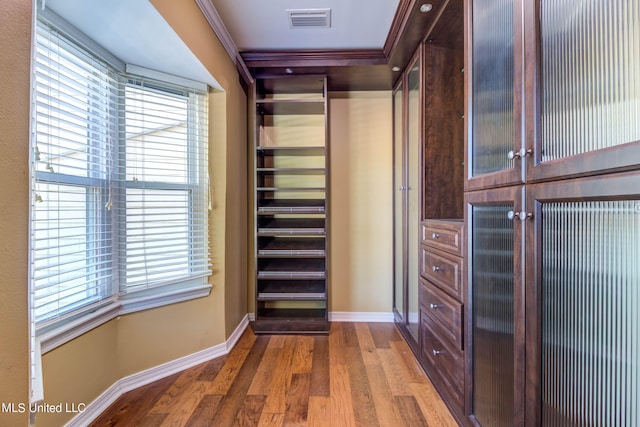 walk in closet with hardwood / wood-style flooring