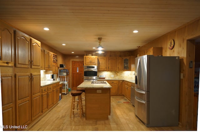 kitchen featuring a center island, a breakfast bar, appliances with stainless steel finishes, wood ceiling, and light wood-type flooring