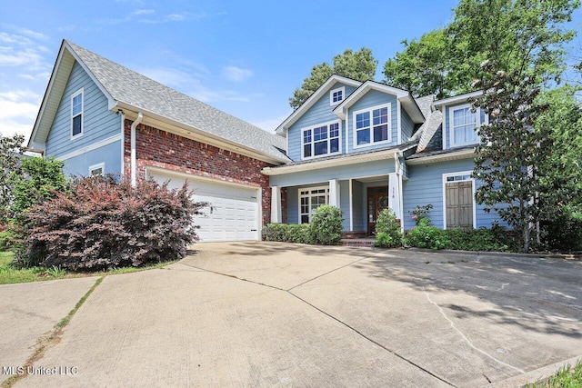 view of front of house with a porch, roof with shingles, and concrete driveway