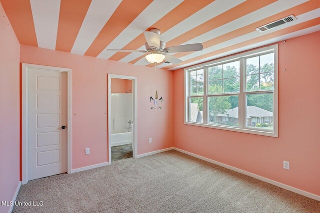 unfurnished bedroom featuring carpet flooring, baseboards, visible vents, and ensuite bathroom