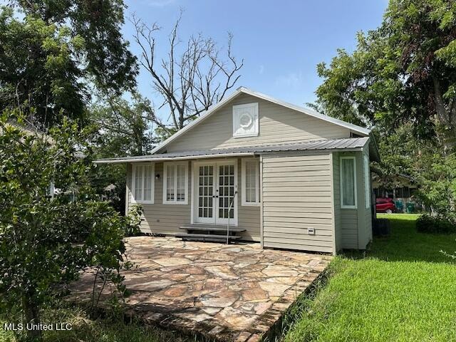 rear view of property with a patio and a yard