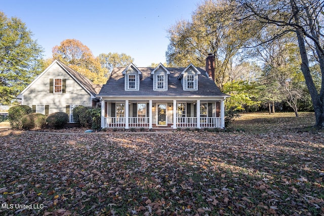 cape cod home featuring covered porch