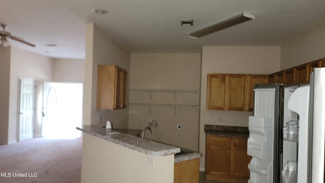 kitchen featuring sink, kitchen peninsula, ceiling fan, white fridge, and light colored carpet