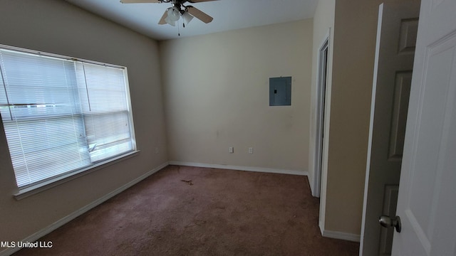 empty room with electric panel, carpet flooring, and ceiling fan