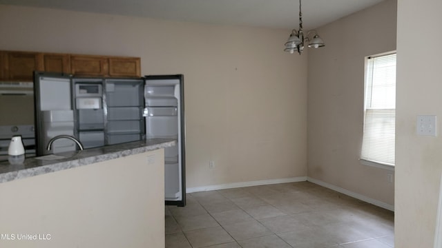 kitchen with a notable chandelier, decorative light fixtures, exhaust hood, and light tile patterned floors