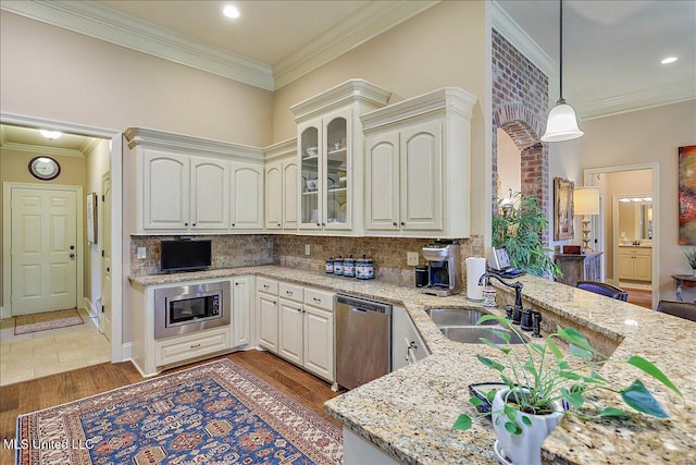 510 Belle Oak Pl, Brandon, MS 39042 - kitchen with a sink, appliances with stainless steel finishes, crown molding, light stone countertops, and light wood-type flooring