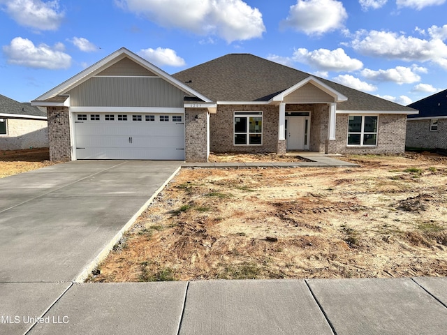 craftsman inspired home with driveway, an attached garage, and brick siding