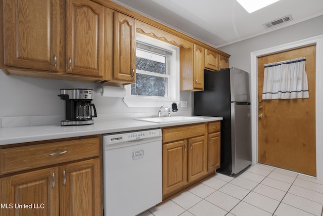 kitchen with light countertops, freestanding refrigerator, visible vents, and dishwasher