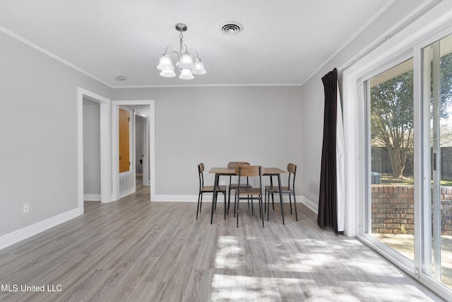 dining space featuring baseboards, crown molding, visible vents, and a notable chandelier