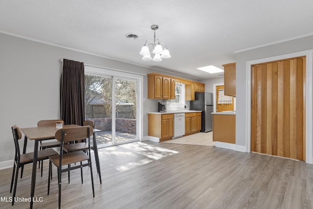 kitchen with a chandelier, visible vents, light countertops, freestanding refrigerator, and dishwasher